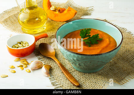 Speziato arrosto di crema di zucca zuppa con il prezzemolo in turchese cup su tela Foto Stock