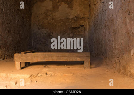 Nafplio, Grecia, 28 dicembre 2015. Il vecchio letto in legno all'interno della vecchia cella di prigione a Palamidi castle in Nafplio Grecia. Foto Stock