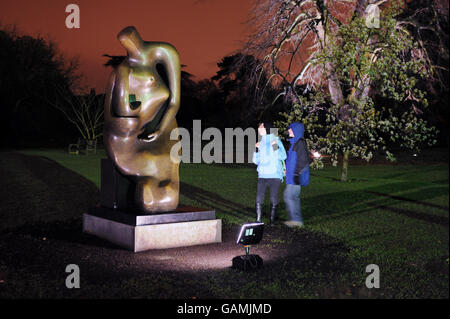 Posto a sedere 1983-84 per la mamma e il bambino di Henry Moore posto contro la Palm House, Kew Gardens, Surrey che ha aperto per due notti alla fine della corsa della mostra con uno spettacolo di luci che illumina alcuni dei 28 lavori degli scultori in mostra. Foto Stock