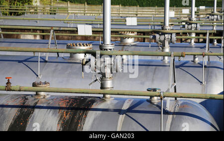 La pipeline e valvola di sicurezza sopra il gigantesco serbatoio a pressione per lo stoccaggio del gas naturale nella fabbrica di raffineria Foto Stock