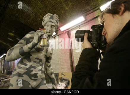 Un fotografo ispeziona 'Brew Period', una statua dell'artista di graffiti Banksy al 'Cans festival' in un tunnel stradale in Leake Street, Lambeth, Londra. Foto Stock