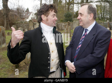 Il primo ministro Alex Salmond (a destra) chiacchierava con Donald Kay, vestito come Robert Burns durante la riapertura della chiesa e del cimitero di Alloway Auld Kirk nel South Ayrshire, Scozia. Foto Stock