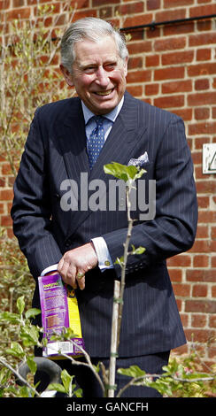 Il Principe di Galles, a destra, reagisce aprendo una borsa, durante una visita alla fattoria della scuola cardinale Wiseman, a Coventry. Foto Stock