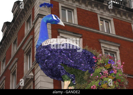 Una delle due sculture in pavone da 25 piedi, create dal designer di New York Preston Bailey, si trova nella piazza di Covent Garden, Londra. Foto Stock