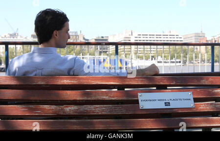 Un uomo si rilassa al sole sulla South Bank di Londra, sfruttando al massimo il clima caldo. Foto Stock