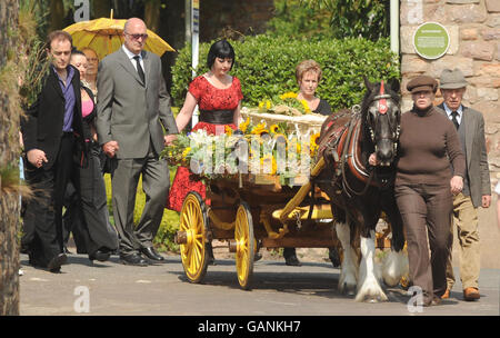 Madre Paula Townsend (centro in abito rosso) segue la bara del figlio Charlie-Bob come viene tirata a tutti i Santi Chiesa per il servizio funerale a Long Ashton vicino Bristol da pony 'Tally'. Foto Stock