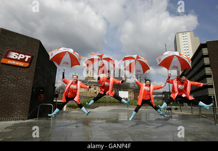 I ballerini di Gambta "Singing in the Rain" si esibiscono sotto una macchina a pioggia alla stazione di Cowcaddens come parte del primo festival della metropolitana di Glasgow. Foto Stock