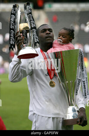 Milton Keynes Dons Jude Stirling solleva il Trofeo League Two mentre sua figlia siede nel Trofeo St Johnstone dopo la partita della Coca-Cola League Two allo stadio: MK, Milton Keynes. Foto Stock