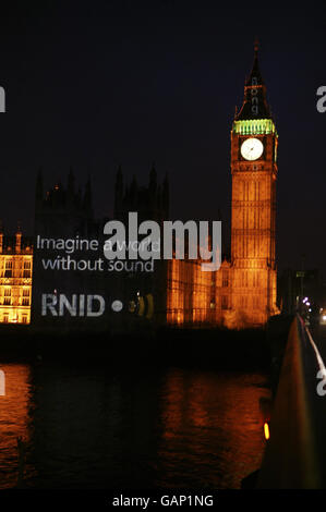 FOTO STANDALONE. RNID, l'associazione benefica per non udenti e per le persone con difficoltà uditive, proietta un'immagine sulle Camere del Parlamento e sulla Torre di Santo Stefano, che rappresenta il 'sottotitolaggio' di Londra e i suoni del Big ben. Foto Stock