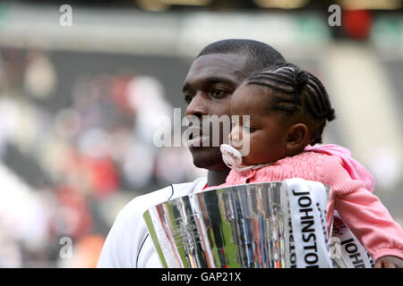 Milton Keynes Dons Jude Stirling sfila il trofeo League 1 con sua figlia Foto Stock