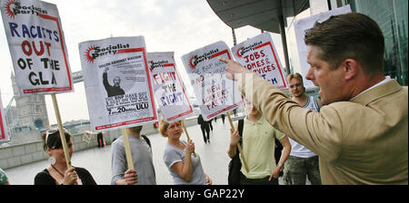 Richard Barnbrook, membro dell'Assemblea di Londra del BNP, affronta i manifestanti al di fuori del municipio di Londra. Foto Stock