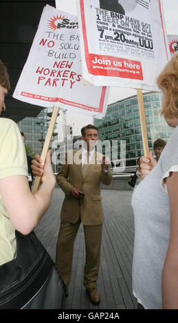 Richard Barnbrook, membro del BNP London Assembly, si trova di fronte a manifestanti al di fuori del City Hall di Londra. Foto Stock