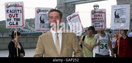 Richard Barnbrook, membro del BNP London Assembly, si trova di fronte a manifestanti al di fuori del City Hall di Londra. Foto Stock