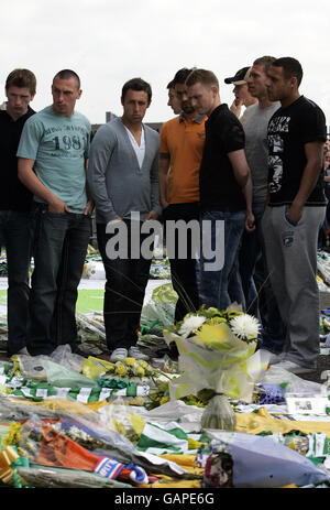 Calcio - Tribute Tommy Burns - Celtic Park. I giocatori celtici guardano i fiori dopo che gli omaggi sono rimasti per Tommy Burns al Celtic Park, Glasgow. Foto Stock