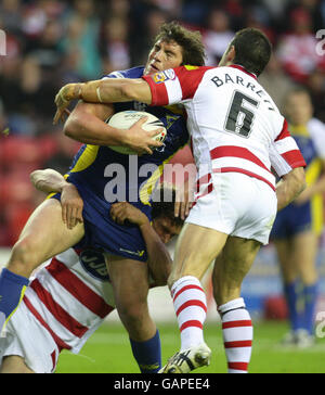 Il ben Harrison di Warrington è affrontato da Sean o'Loughlin di Wigan (a sinistra) e Trant Barrett durante la partita di Engage Super League al JJB Stadium di Wigan. Foto Stock