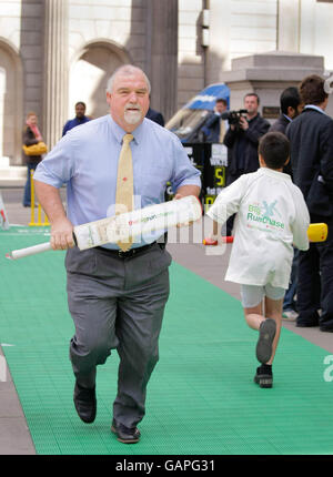 Mike Gatting, ex capitano di cricket dell'Inghilterra, prova il campo di cricket fuori dal Royal Exchange, Londra per il lancio di "The Big Run Chase" oggi, il National Cricket Day. Foto Stock