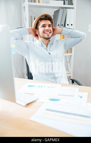 Allegro giovane hat seduto e rilassante in ufficio Foto Stock