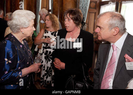 La Regina Elisabetta II della Gran Bretagna parla con la signora Debra Johnson e il signor Andrew Tallett del caffè della comunità di Donnington Wood ad un ricevimento per il Queen's Award per il servizio volontario a Buckingham Palace, Londra. Foto Stock