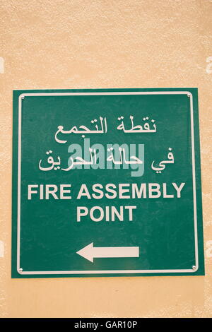 Sign in arabo e in inglese che indica punto di raduno in caso di incendio in un hotel, Regno del Bahrein Foto Stock