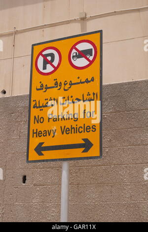 Sign in arabo e in inglese che indica assenza di parcheggio per veicoli pesanti, Regno del Bahrein Foto Stock