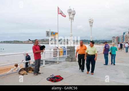 Musicista di strada giocando l'asturiano bag-tubo sul lungomare. Gijon, Asturias, Spagna. Foto Stock