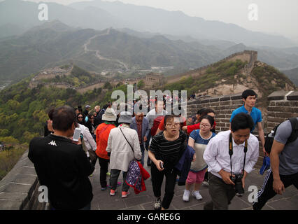 Un sacco di turisti, si prende le foto con uno smartphone, salire la Grande Muraglia della Cina andando lungo le aspre montagne. Badaling vicino a Pechino, in Cina. Foto Stock
