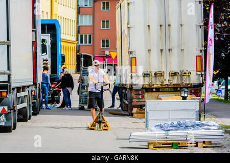 Motala, Svezia - 21 Giugno 2016: Giovani maschi adulti utilizzando un carrello per il trasporto di lui verso una cassa che deve essere caricato per un Foto Stock