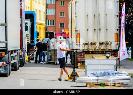 Motala, Svezia - 21 Giugno 2016: Giovani maschi adulti utilizzando un carrello per il trasporto di lui verso una cassa che deve essere caricato per un Foto Stock