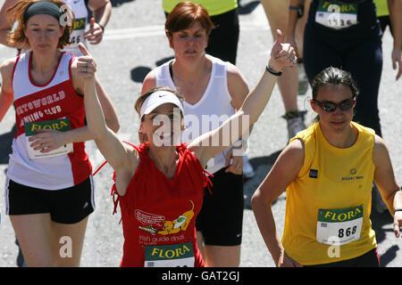 Uno dei 40,000 corridori attraversa la linea di partenza della Mini Maratona Flora Women di 10 chilometri a Dublino, Irlanda. Foto Stock