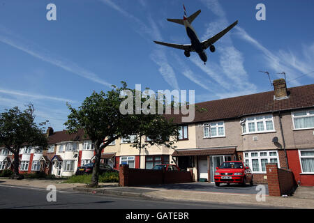 Una fotografia generica di un aereo che vola in basso su una proprietà di alloggi locali, sul suo approccio finale per atterrare a Heathrow Airpor Foto Stock