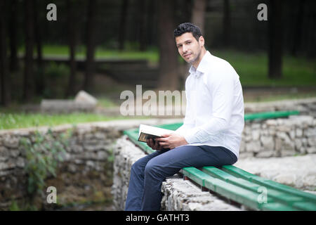 Adulto Uomo musulmano è la lettura del Corano all'aperto Foto Stock