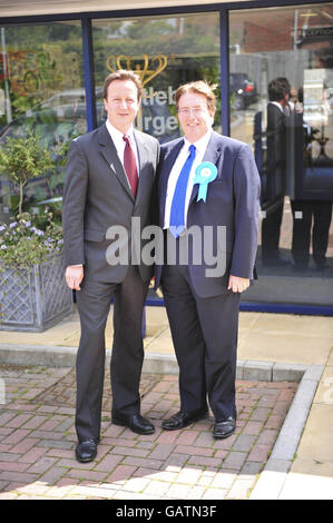 John Howell, destra, il candidato del partito conservatore per la by-elezione di Henley-on-Thames con il leader conservatore David Cameron, è partito, durante una visita alla chirurgia di Nettlebed nel collegio elettorale. Foto Stock