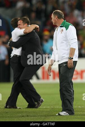 L'assistente allenatore tedesco Hansi Flick festeggia con il Team Manager tedesco Oliver Bierhoff dopo il fischio finale come vettura portoghese Luiz Felipe Scolari guarda su deposto Foto Stock