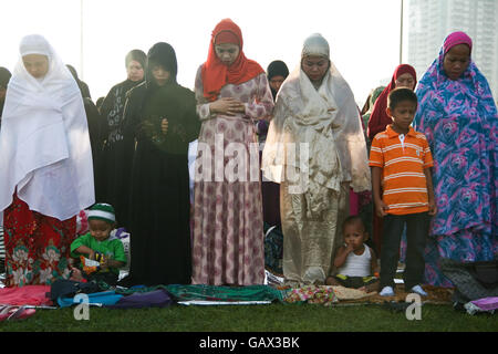 Filippine. 6 Luglio, 2016. I bimbi a mangiare mentre gli adulti unirsi alla preghiera del mattino al Quirino Grandstand. I musulmani filippini dalla vicina città fatta convergere al Quirino Grandstand a Manila per festeggiare la fine del Ramadan. Eid al-Fitr segna la fine del mese sacro del digiuno in Islam. © J Gerard Seguia/ZUMA filo/Alamy Live News Foto Stock