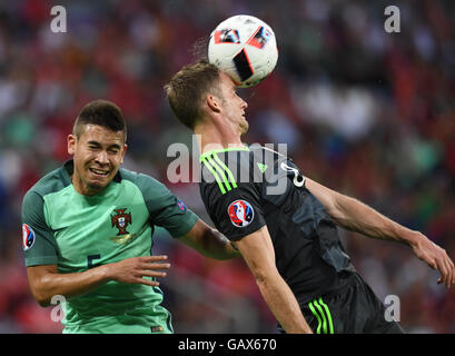 Lione, Francia. 06 Luglio, 2016. Raphael Guerreiro (L) del Portogallo e Andy King del Galles si contendono la palla durante UEFA EURO 2016 semifinale partita di calcio tra il Portogallo e il Galles allo Stade de Lyon a Lione, Francia, 06 luglio 2016. Foto: Arne Dedert/dpa/Alamy Live News Foto Stock