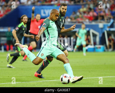 Lione, Francia. 06 Luglio, 2016. Joao Mario (c) del Portogallo e Joe Ledley del Galles si contendono la palla durante UEFA EURO 2016 semifinale partita di calcio tra il Portogallo e il Galles allo Stade de Lyon a Lione, Francia, 06 luglio 2016. Foto: Christian Charisius/dpa/Alamy Live News Foto Stock