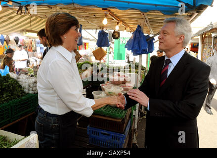 Il deputato conservatore David Davis si è dimesso con Janet Devers nel suo stand di frutta e verdura sul mercato di Ridley Road a Hackney, a est di Londra. Foto Stock