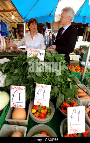 Il deputato conservatore David Davis si è dimesso con Janet Devers nel suo stand di frutta e verdura sul mercato di Ridley Road a Hackney, a est di Londra. Foto Stock