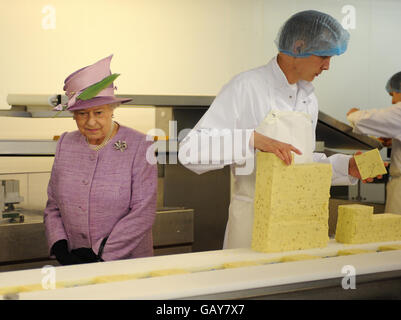 La Regina Elisabetta II della Gran Bretagna guarda il processo di produzione del formaggio durante una visita a Singleton's Dairy, Longridge, Lancashire. Foto Stock
