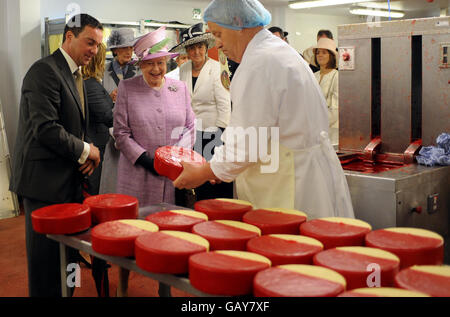 La Regina Elisabetta II della Gran Bretagna parla con Bill Riding (a sinistra) mentre guarda il processo di produzione del formaggio durante una visita al caseificio di Singleton, Longridge, Lancashire. Foto Stock