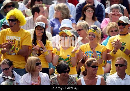 Un gruppo di spettatori in giallo sulla Lleyton Hewitt australiana dagli stand durante i Wimbledon Championships 2008 presso l'All England Tennis Club di Wimbledon. Foto Stock