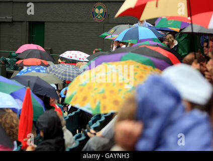 Tennis - Wimbledon Championships 2008 - Day Nine - The All England Club. Gli spettatori si coprono sotto gli ombrelloni sul cortile centrale Foto Stock