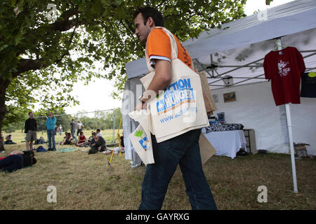 Un uomo consegna borse che promuovono l'azione contro la fame al festival Subway picnic Rocks su Clapham Common, a sud di Londra. Foto Stock