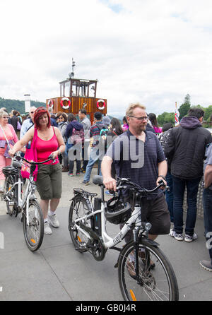 FreeGo biciclette elettriche ebikes arrivando a Bowness sul Lago di Windermere dopo una crociera sul Lago Foto Stock