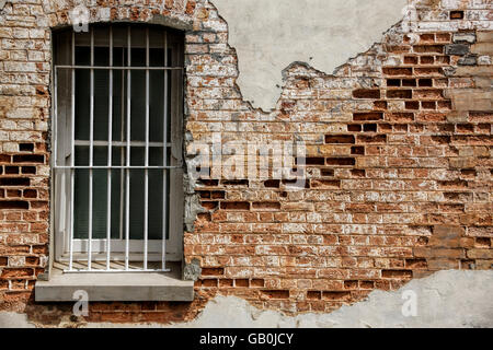 Vecchia finestra con barre impostato in argilla di decadimento muro di mattoni, Albany Australia Occidentale Foto Stock