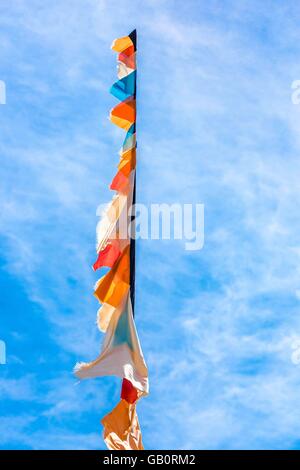 Un pennone con bandiere e bandierine salendo in un cielo blu Foto Stock