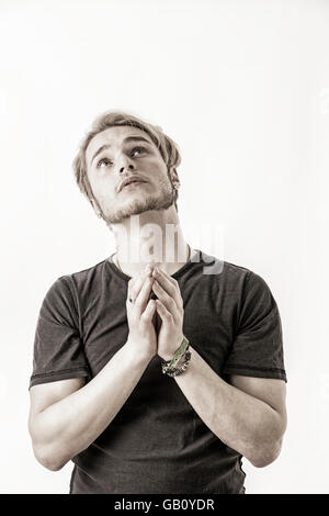 I bisognosi, disperata giovane supplica con le mani giunte come se pregando per fotocamera, isolato Foto Stock