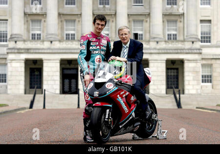 Il Ministro della Cultura, delle Arti e del tempo libero Gregory Campbell (a destra) si unisce al pilota Conor Cummings (a sinistra) in una foto per lanciare la corsa motociclistica del Gran Premio dell'Ulster, oggi presso il Parlamento di Belfast. Foto Stock