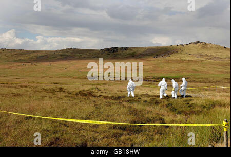 Gli ufficiali forensi della polizia cercano un'area di terra a Saddleworth Moor vicino Oldham dopo che sono stati scoperti i resti. Foto Stock
