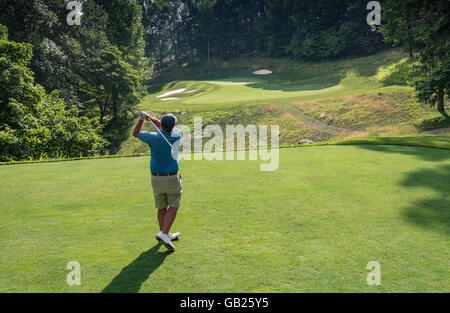 Vista da dietro il Golfer come egli oscilla Off tee da golf Foto Stock